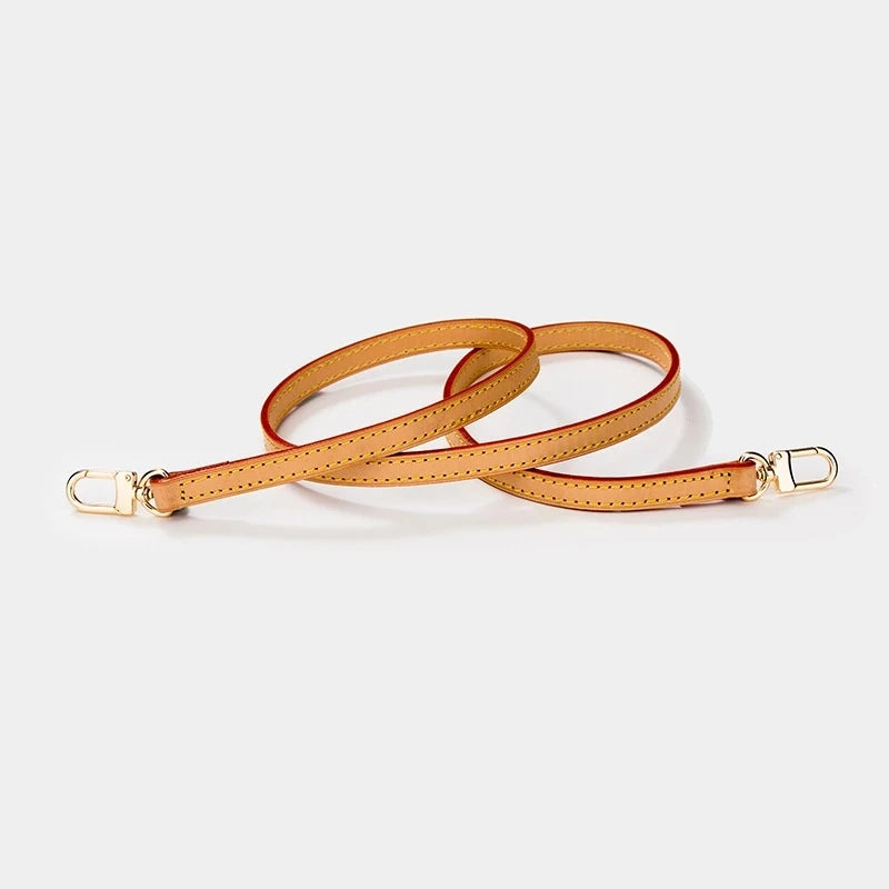 A genuine Vachetta leather handbag strap in tan with gold-tone buckles.