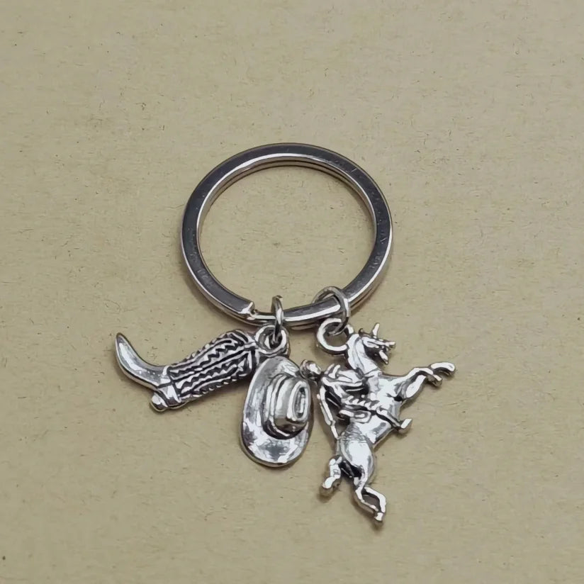 Silver keychain set featuring a cowboy boot, hat, and horse silhouette.