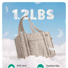 A beige quilted tote bag with a detachable strap is shown against a soft, cloudy background.