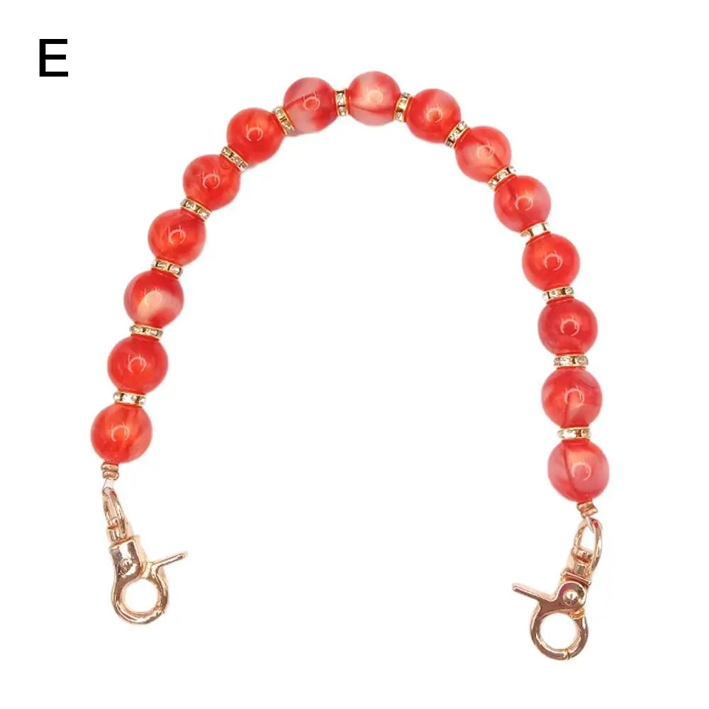 Handcrafted resin stone bead bag chain with round reddish-orange beads and gold clasps