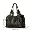 A black vintage washed leather tote bag shown from the side with a zipper pocket and leather handles.