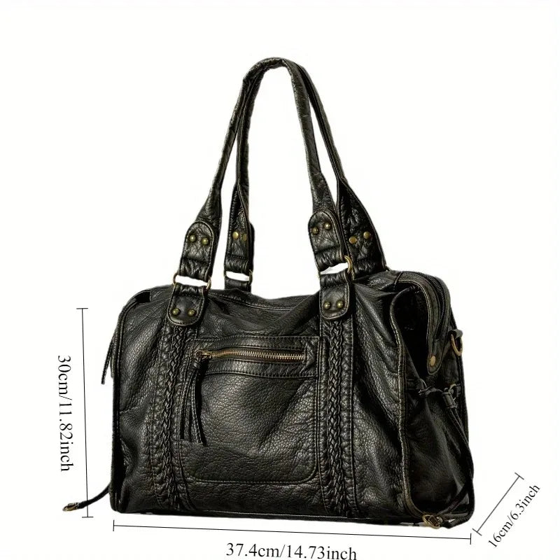 A black vintage washed leather tote bag shown from the side with a zipper pocket and leather handles.