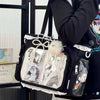 A black shoulder tote bag with a transparent front featuring various charms and designs.