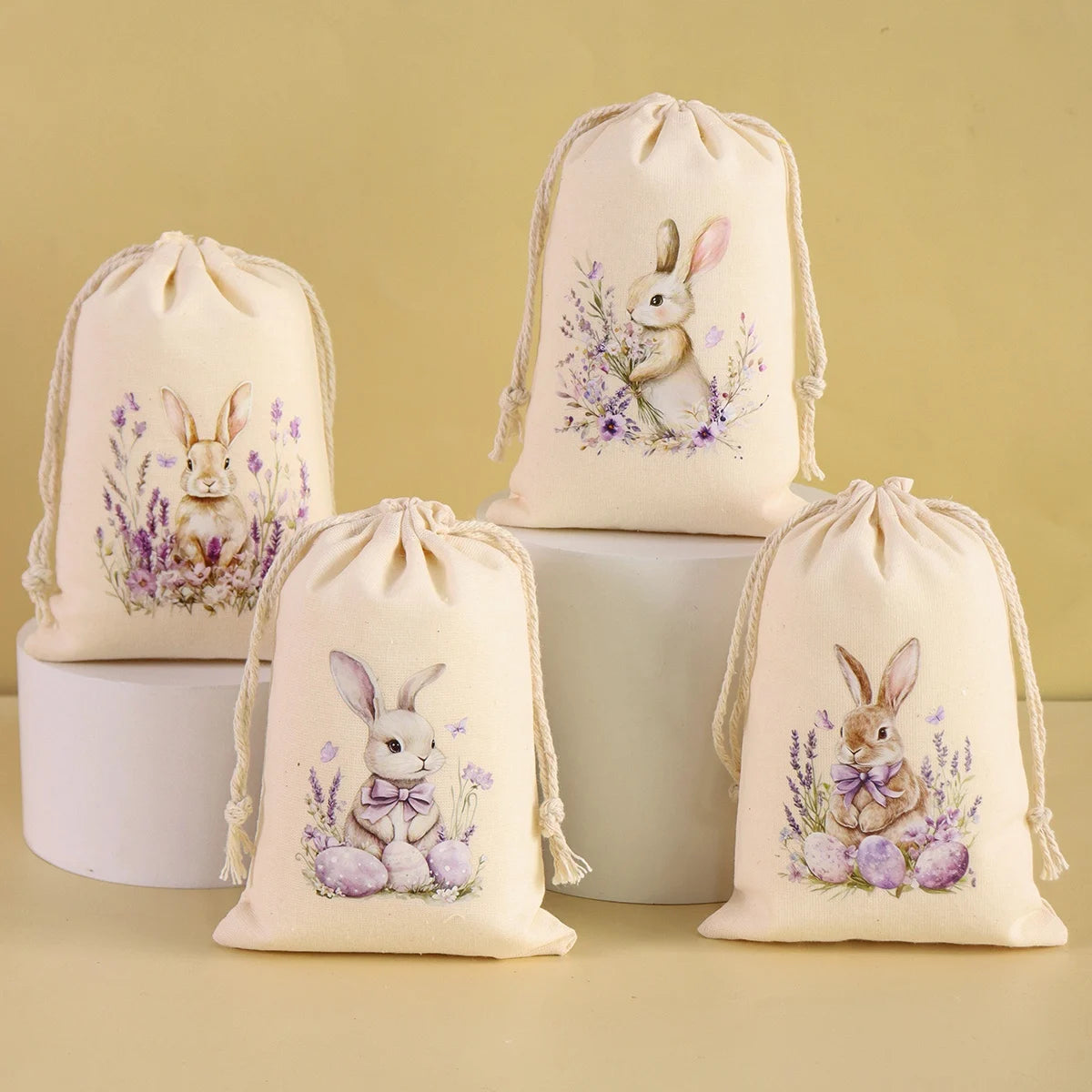 A set of six light beige drawstring gift bags featuring illustrations of rabbits and purple flowers.