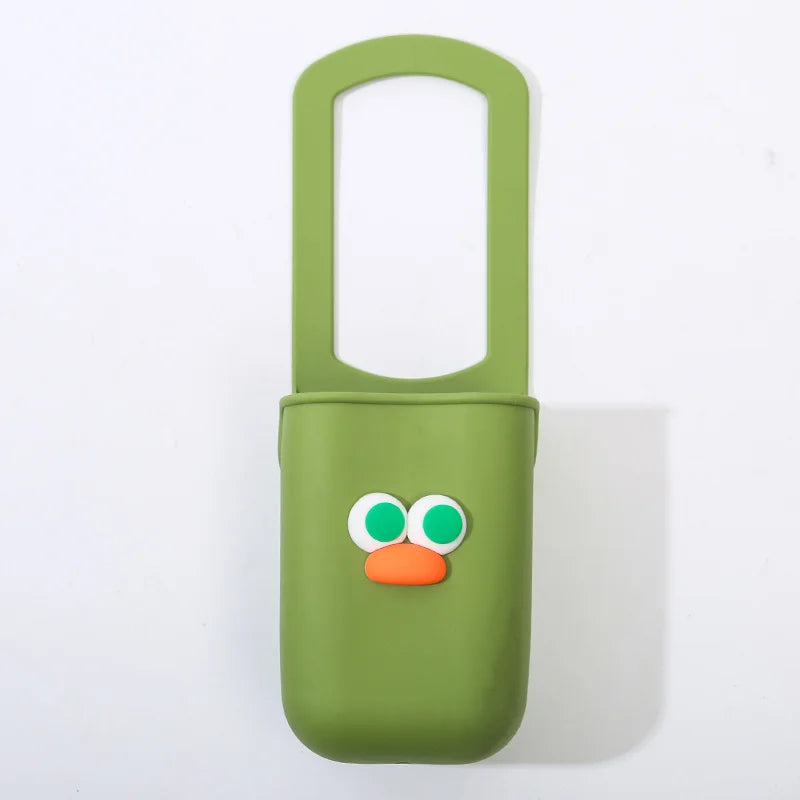 A light green silicone cup holder with a cute orange face design.