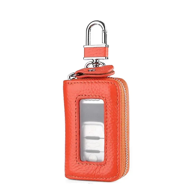 Orange leather car key case with a transparent window and a metal latch.