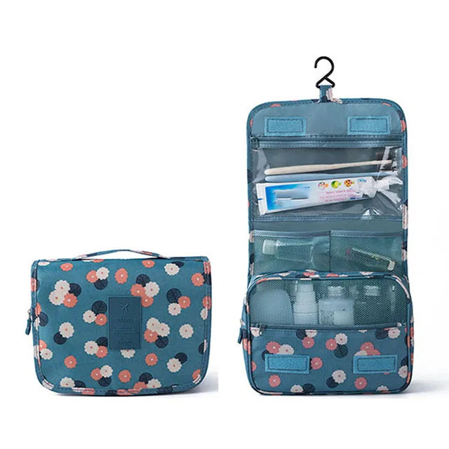 A teal multi-compartment travel pouch with a floral print, featuring various internal pockets and a hanging loop.