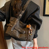 A black leather jacket is shown holding a leopard print casual tote bag with decorative beads.