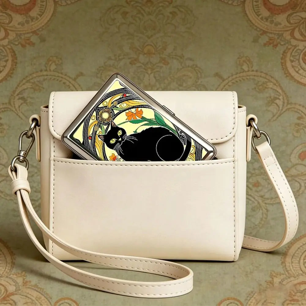 A light beige leather card holder with a black cat design is shown against a patterned background.