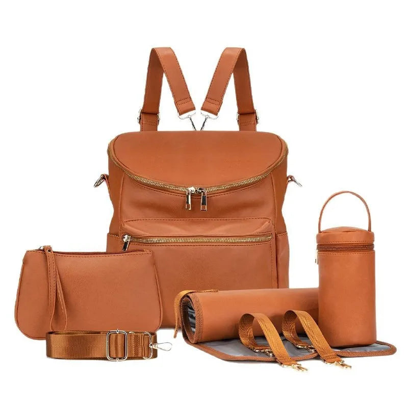 A tan leather backpack diaper bag with a front pocket and an attached pouch is shown.