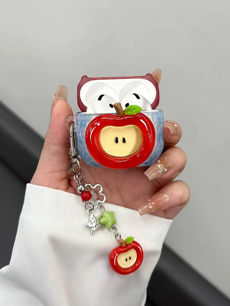 A hand holds a cute fruit design earphone case shaped like an apple, featuring white and red colors.