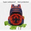 An orange and black spider-themed backpack is shown against a blurred background with rain.