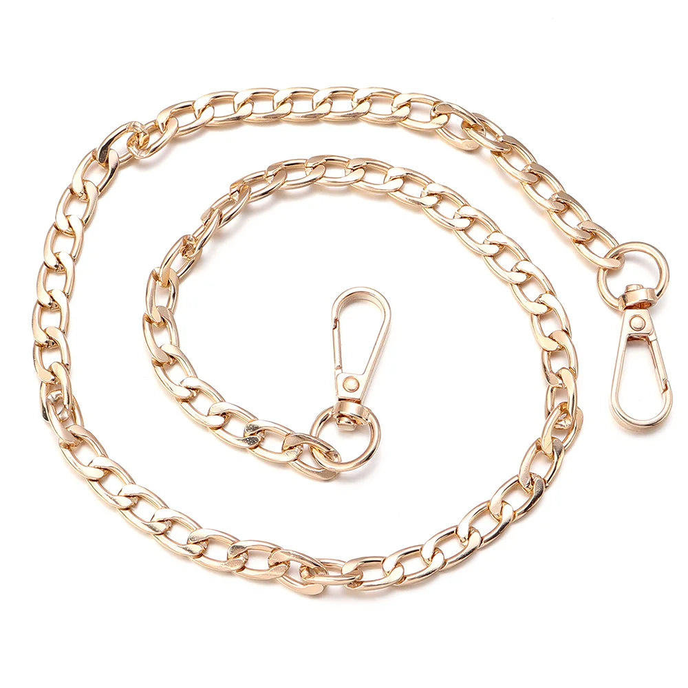 A gold-toned adjustable metal bag strap chain laid out in a circular shape.