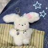 A fluffy white bunny charm attached to a silver chain is displayed against a denim background.