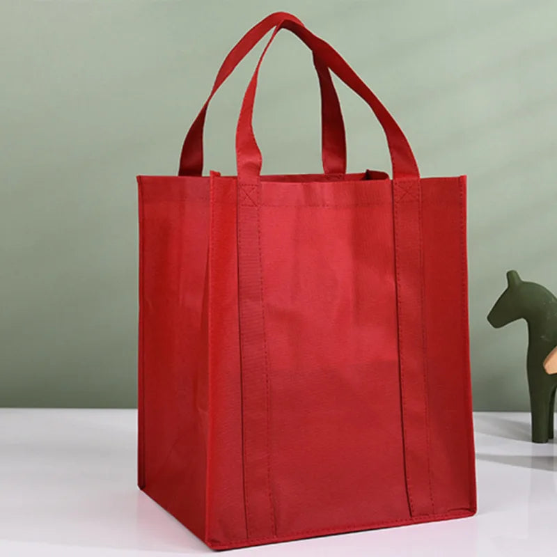 A bright red reusable eco-friendly tote bag standing upright on a white surface.