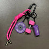 A pink and black fitness keychain featuring a purple disc and a purple sports bottle.