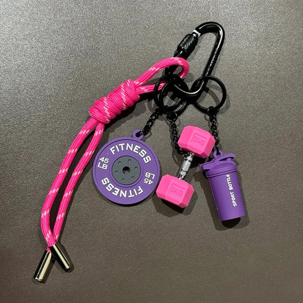 A pink and black fitness keychain featuring a purple disc and a purple sports bottle.