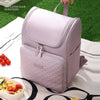 A light purple insulated travel backpack is shown resting on a white cloth next to fresh food.