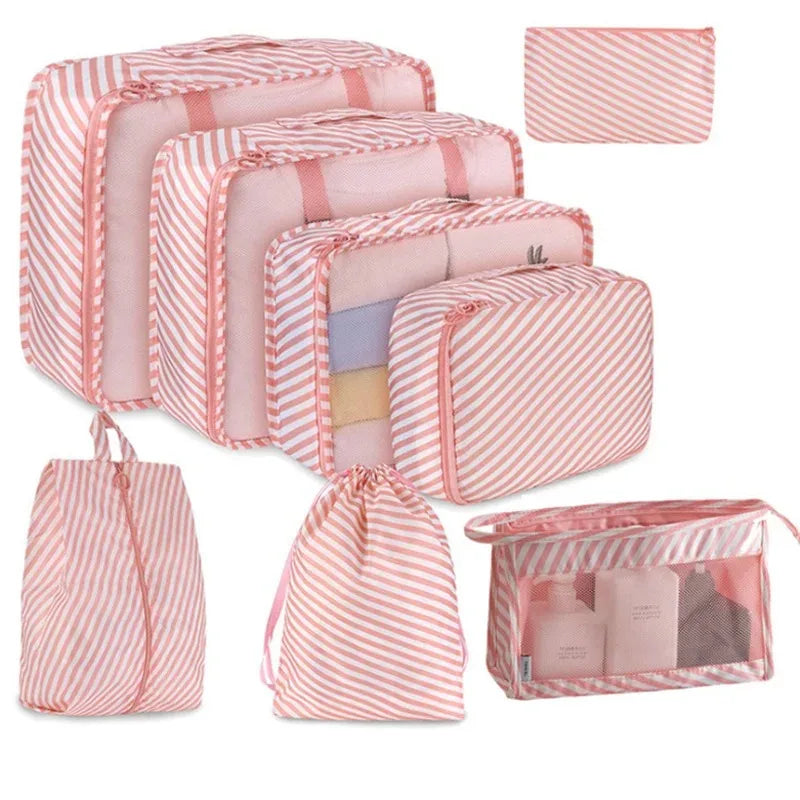 A set of multi-size mesh packing cubes in pink and white stripes for travel organization.