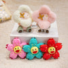 Three pink and yellow sunflower plush keychains displayed on a white box.