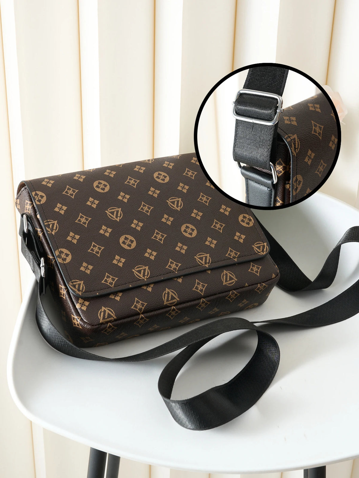 A brown patterned men's casual crossbody bag with a black strap is shown on a white surface.