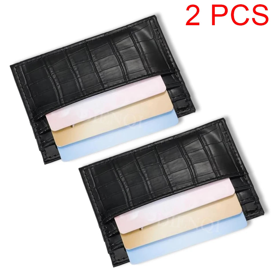 Two black crocodile pattern slim card holder wallets with light colored cards inside
