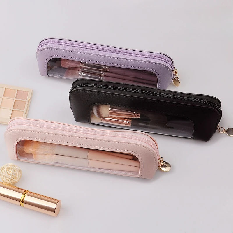 Three cosmetic organizer pouches in lavender, black, and pink holding makeup brushes.