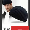 A close-up of a man wearing a black slouchy knit beanie hat.