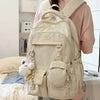 A light beige Kawaii Harajuku backpack with a laptop compartment being worn by a person.