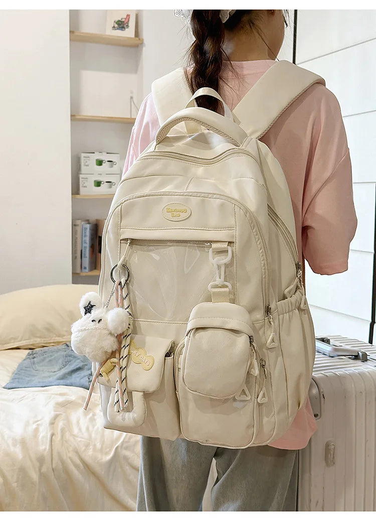 A light beige Kawaii Harajuku backpack with a laptop compartment being worn by a person.