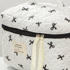 White quilted makeup bag with black ribbon details and a black zipper.