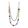 A silver chain necklace featuring colorful dice charms in yellow, purple, black, and orange.
