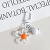 A white metal keychain featuring a clear resin flower charm with an orange center.