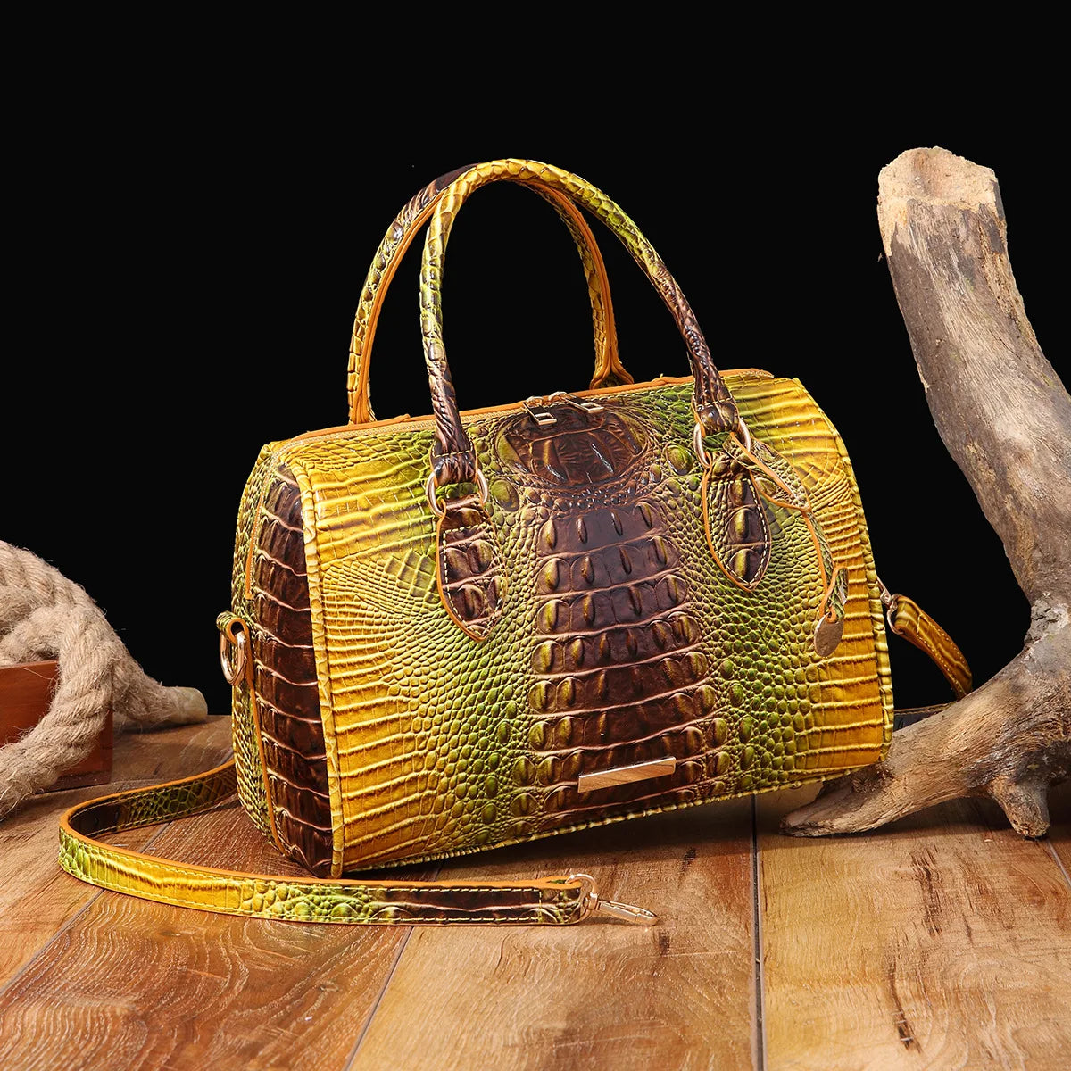 A luxury crocodile pattern leather crossbody tote bag in yellow and brown tones resting on a wooden surface.