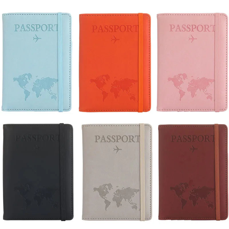 A set of four leather passport organizers in blue, orange, pink, and dark gray colors.