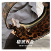 A close-up of a leopard print PU leather mini tote handbag with gold hardware and a yellow zipper on the top.