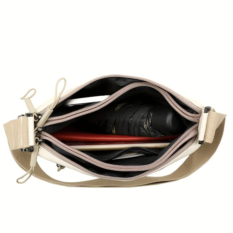 A beige nylon crossbody shoulder bag with multiple zippered compartments shown open.