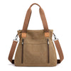 A tan canvas tote bag with brown leather handles and pockets shown against a white background.