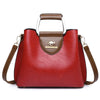 Sac bandoulière vintage en cuir rouge profond avec poches, garniture marron et poignée argentée.
