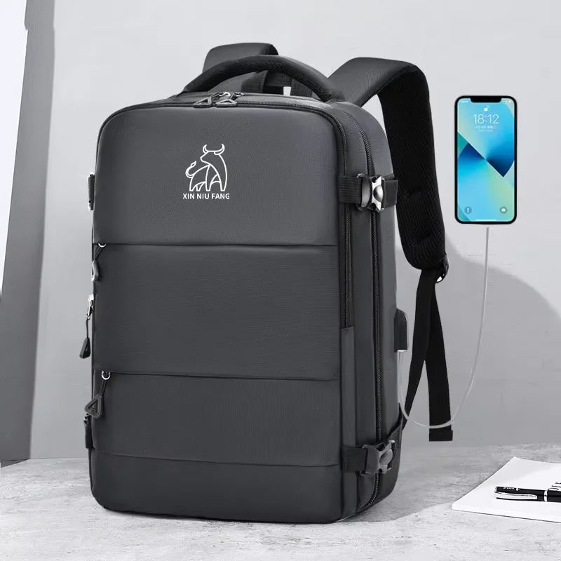 A dark gray expandable travel backpack with black straps and buckles is shown next to a smartphone.