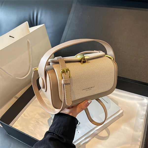 Beige Leder-Crossbody-Tasche in einer schwarzen Box mit hellem Hintergrund
