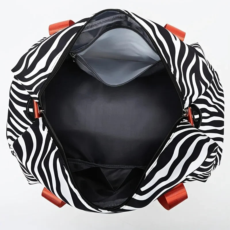 A black and white striped nylon travel duffle bag shown open, revealing the interior.