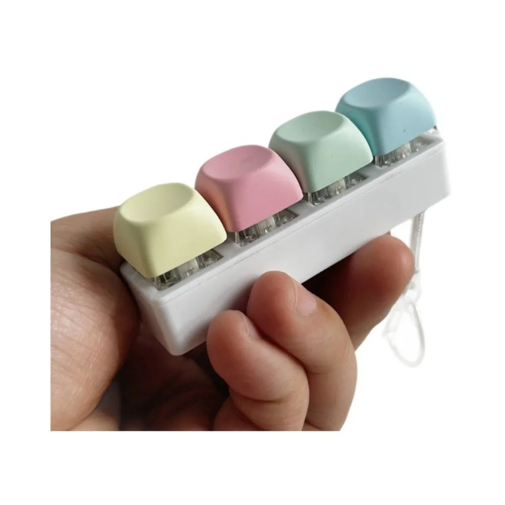 A hand holds a white tactile stress relief keyboard fidget toy with multiple colored buttons.