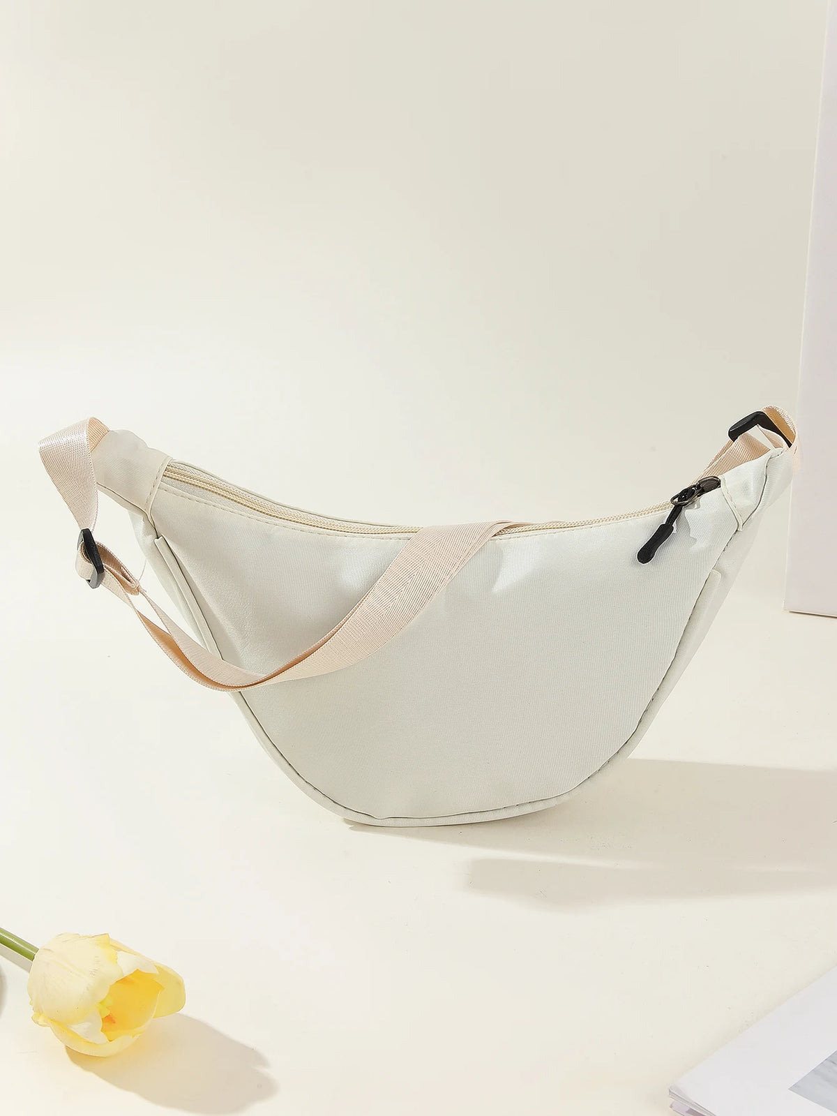 A light beige women's preppy sling crossbody bag is shown against a white background.