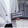 Portefeuille à fermeture éclair marron foncé pour homme, tenu par une personne en blazer gris clair.