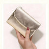 A hand holds a silver metallic leather mini card holder wallet with a textured finish.