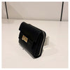 Black leather card holder with gold hardware shown on a white surface.