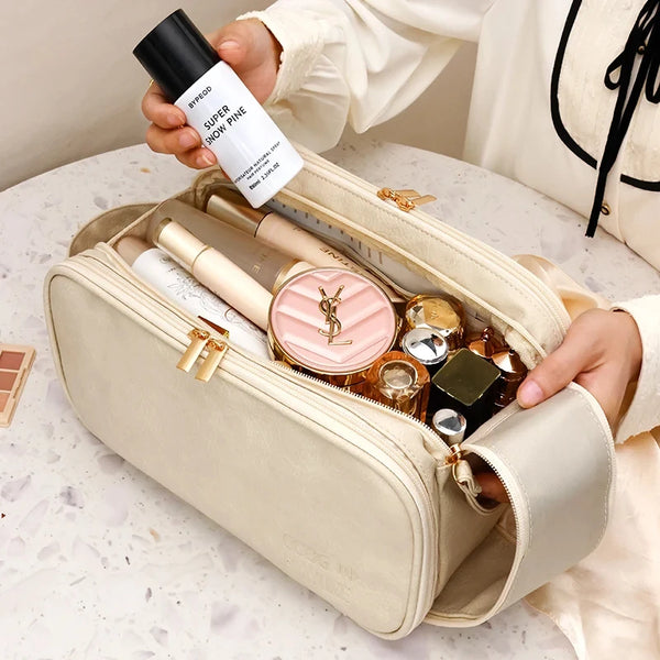 A beige waterproof PU leather travel cosmetic bag is open, displaying various beauty products and a black tube of Super Snow 