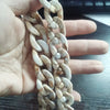 A hand holds a necklace made of multicolor acrylic chain bracelets.