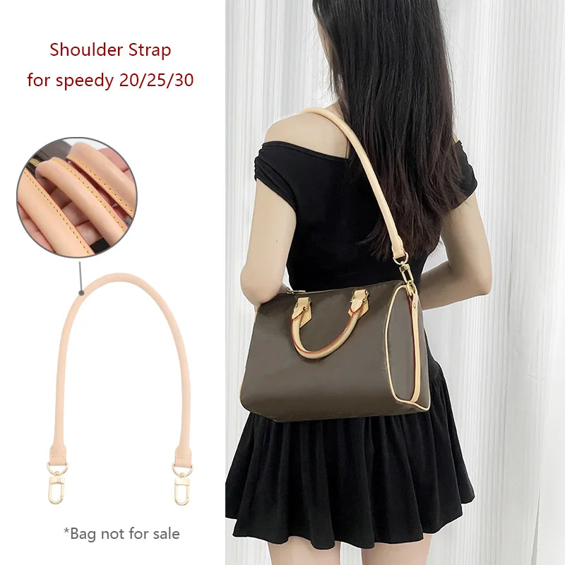 A woman is holding a brown leather shoulder strap attached to a dark green bag.